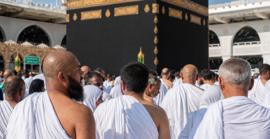 Ilustrasi jamaah di depan Ka'bah untuk menjelaskan perbedaan haji dan umroh secara lengkap.