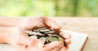 The woman's hand is holding many coins