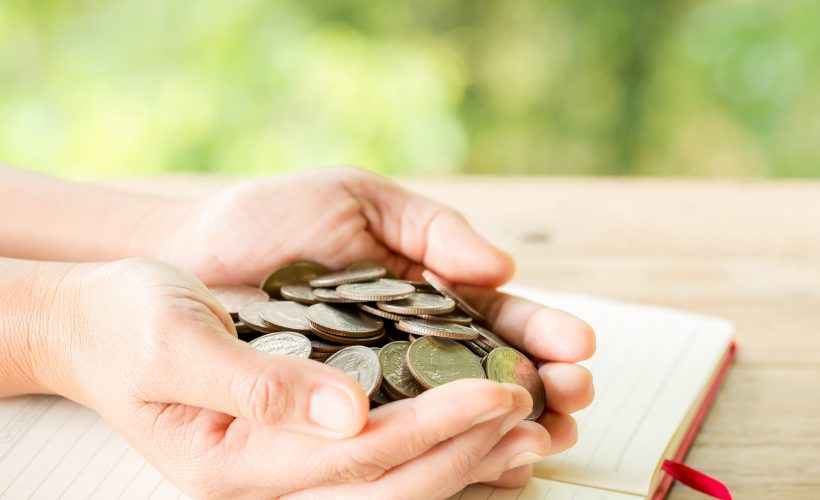 The woman's hand is holding many coins