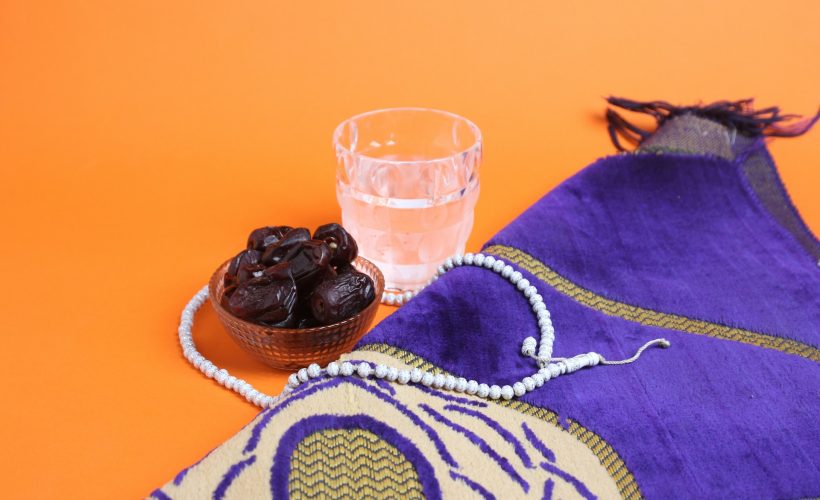a bowl of raisins next to a glass of water