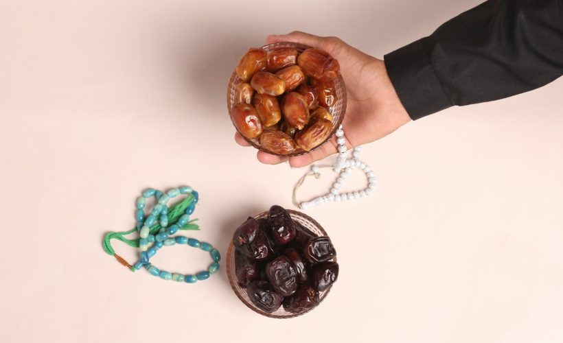 a-person-holding-a-bowl-of-nuts-next-to-a-string-of-beads